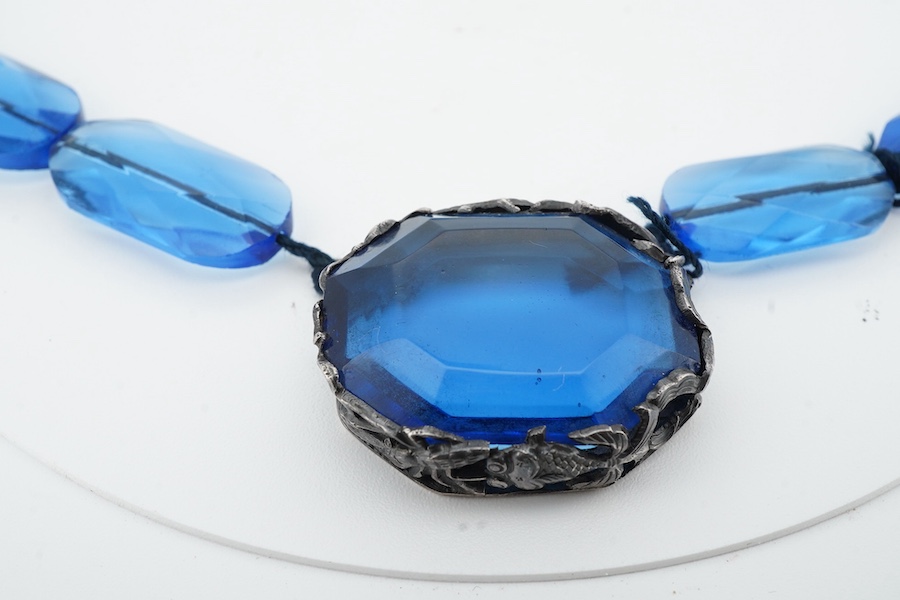 A silver and paste necklace, composed of faceted blue paste beads, the clasp set with a blue paste, in a silver mount decorated with sea creatures, length 40cm, Chinese mark for silver, maker's mark CHC